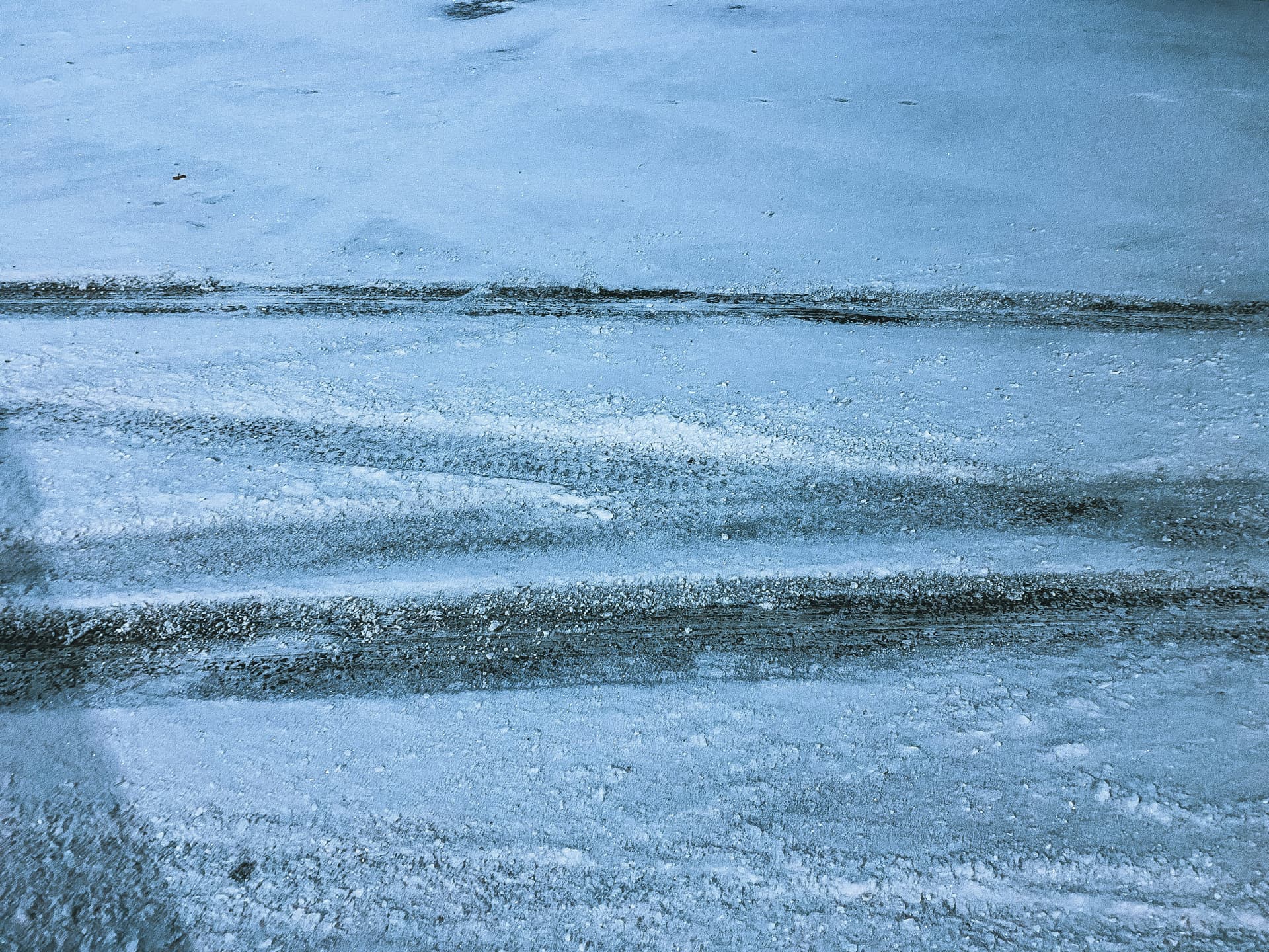 Professional applying ice melt salt to a cleared walkway