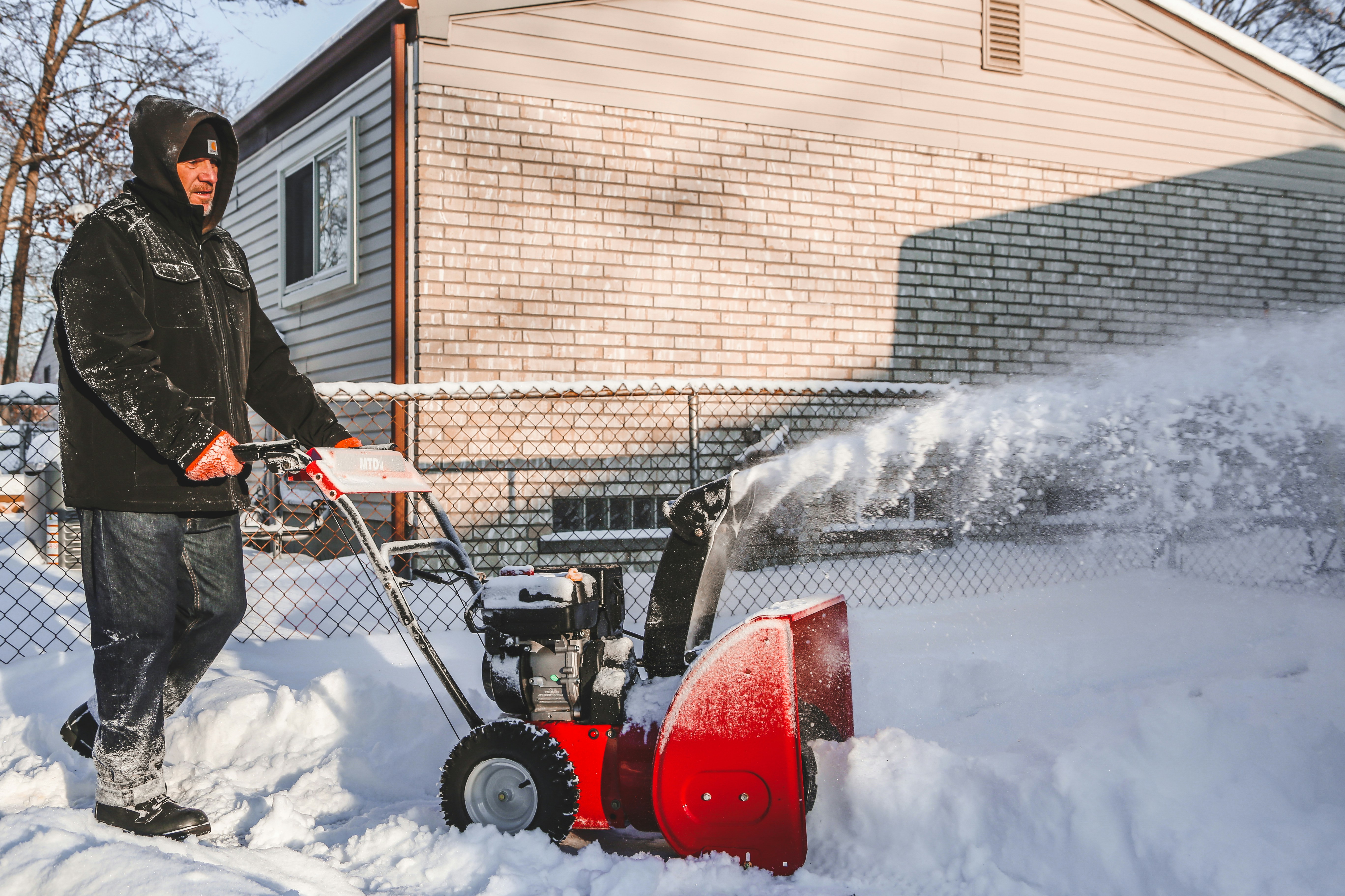 Snow plow clearing a residential driveway in Toronto